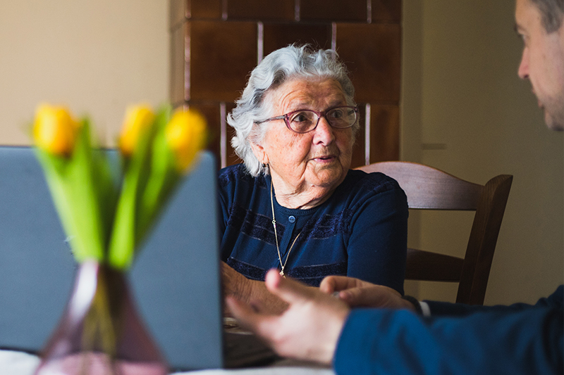 Elderly woman researching cost of home care with family caregiver