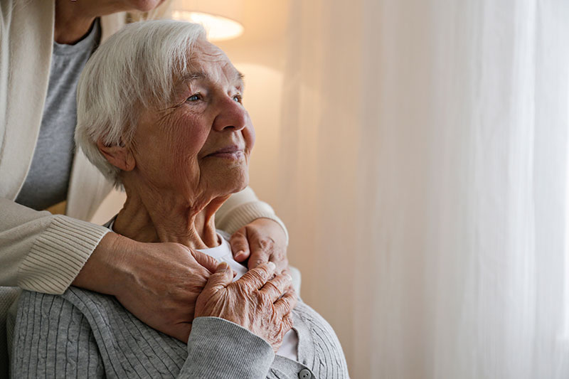 caregiver comforting senior lady