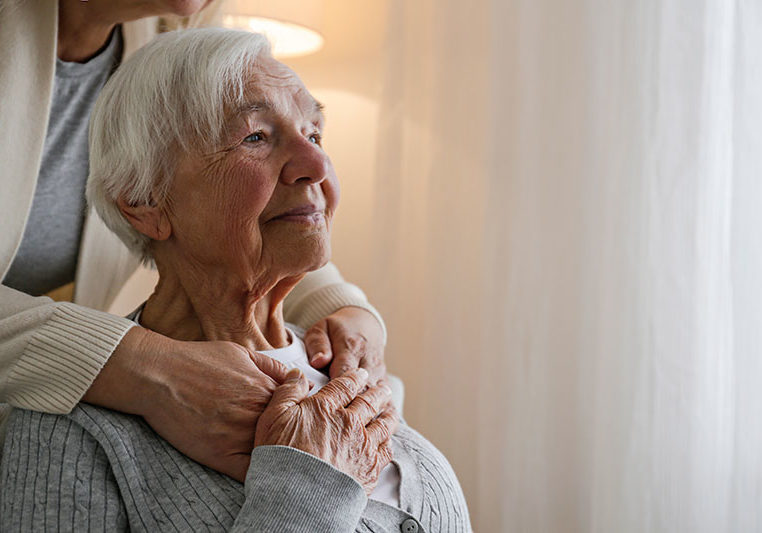 caregiver comforting senior lady